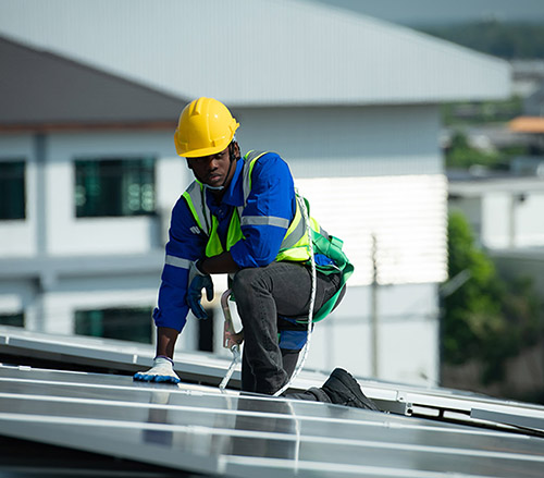 Engineer in charge of solar panel installation The installation of solar energy conversion into electricity for a warehouse is currently being investigated.